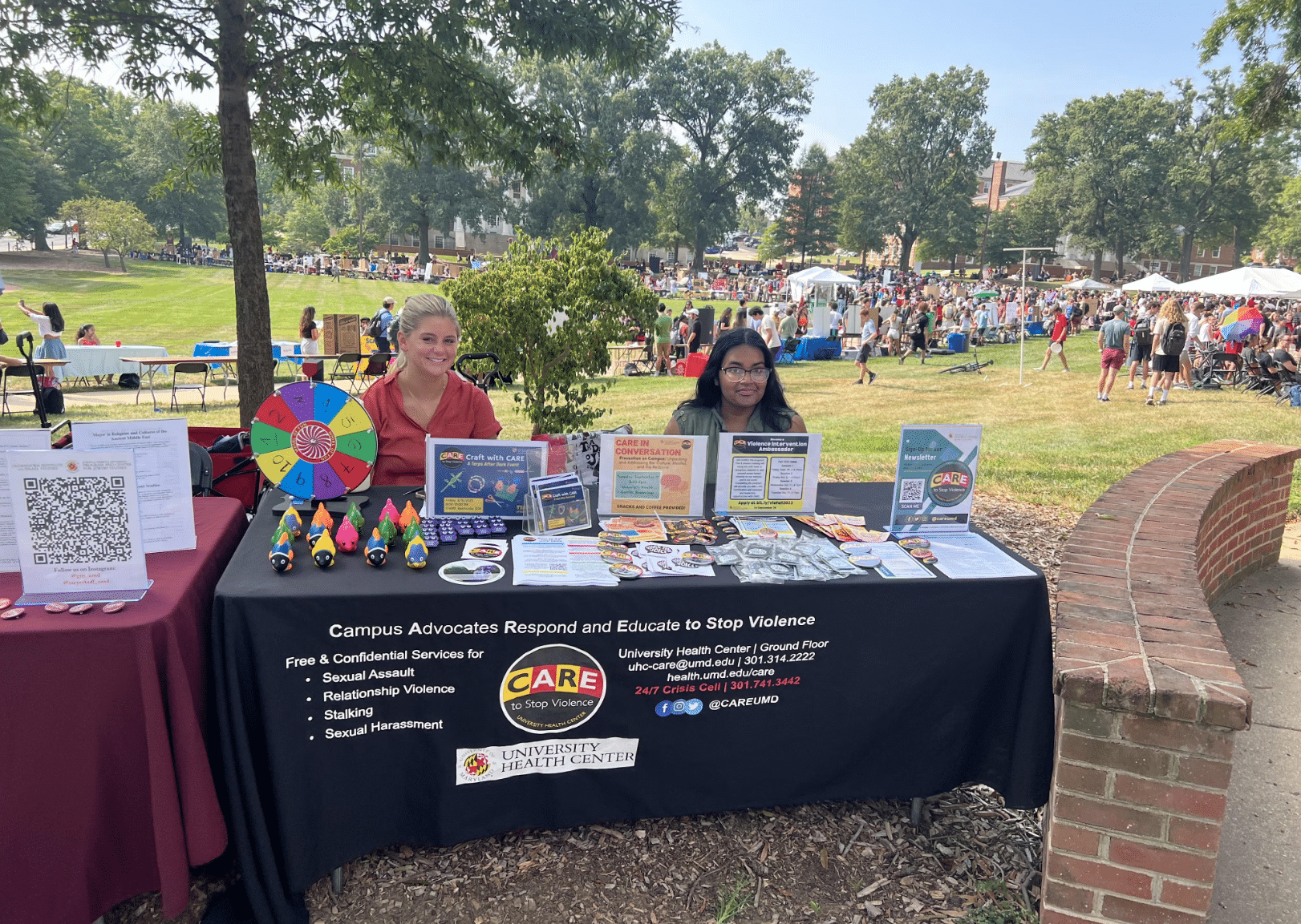 Smiling CARE Staff outside on McKeldin Mall representing CARE to Stop Violence at an outreach event