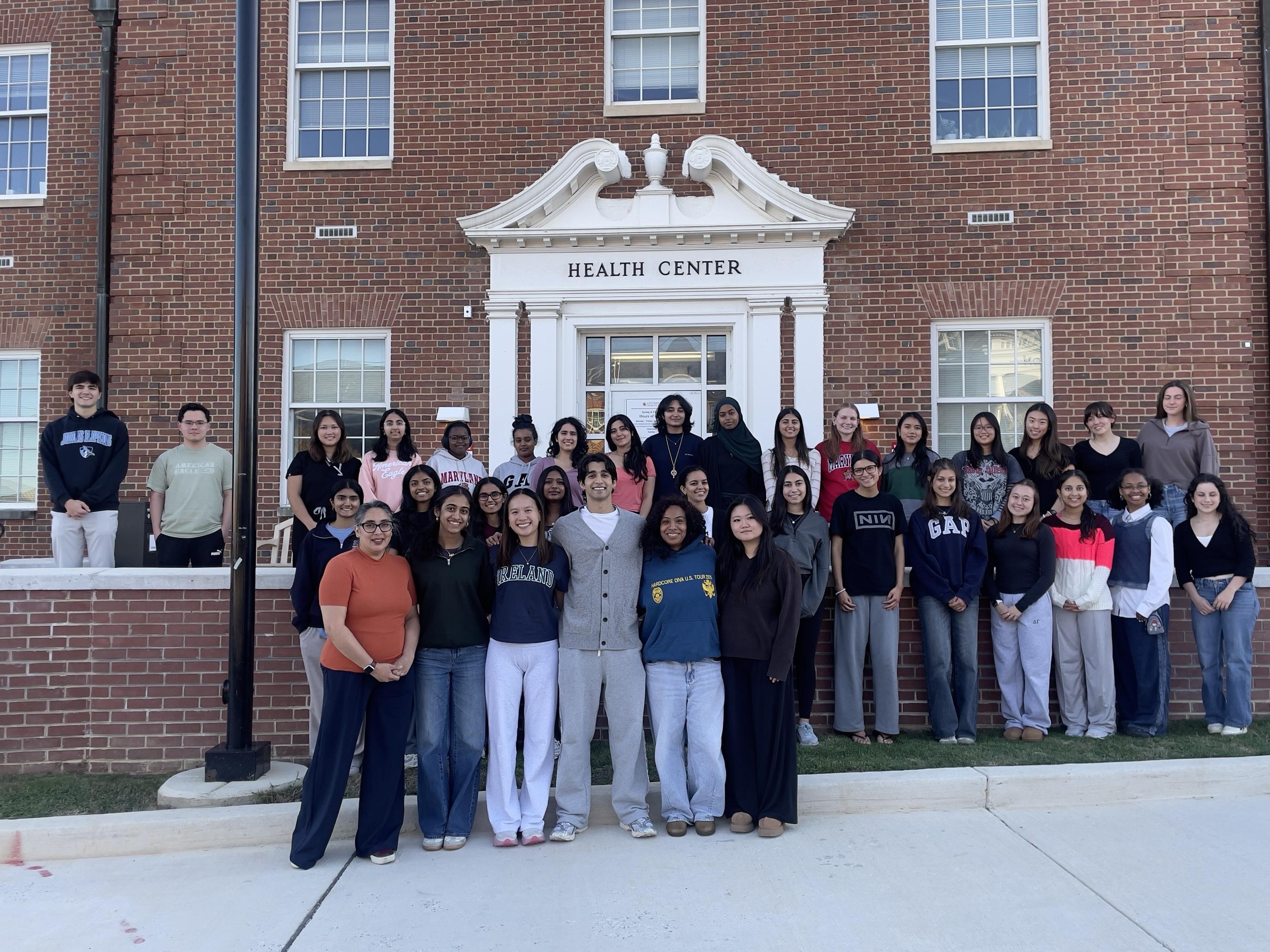 Group photo of the Student Health Advisory Committee standing together in front of the Health Center